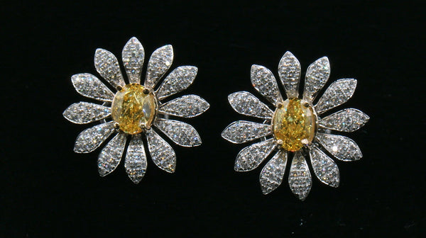 Pair of daisy-shaped diamond earrings with a yellow diamond center stone