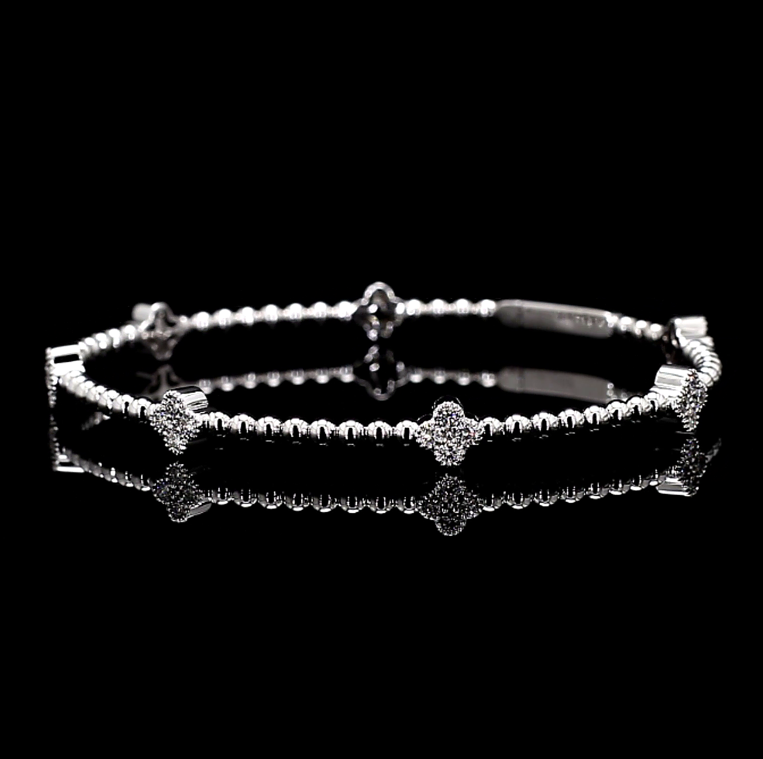 White Gold bracelet with clover charm star and bar designs on a black background