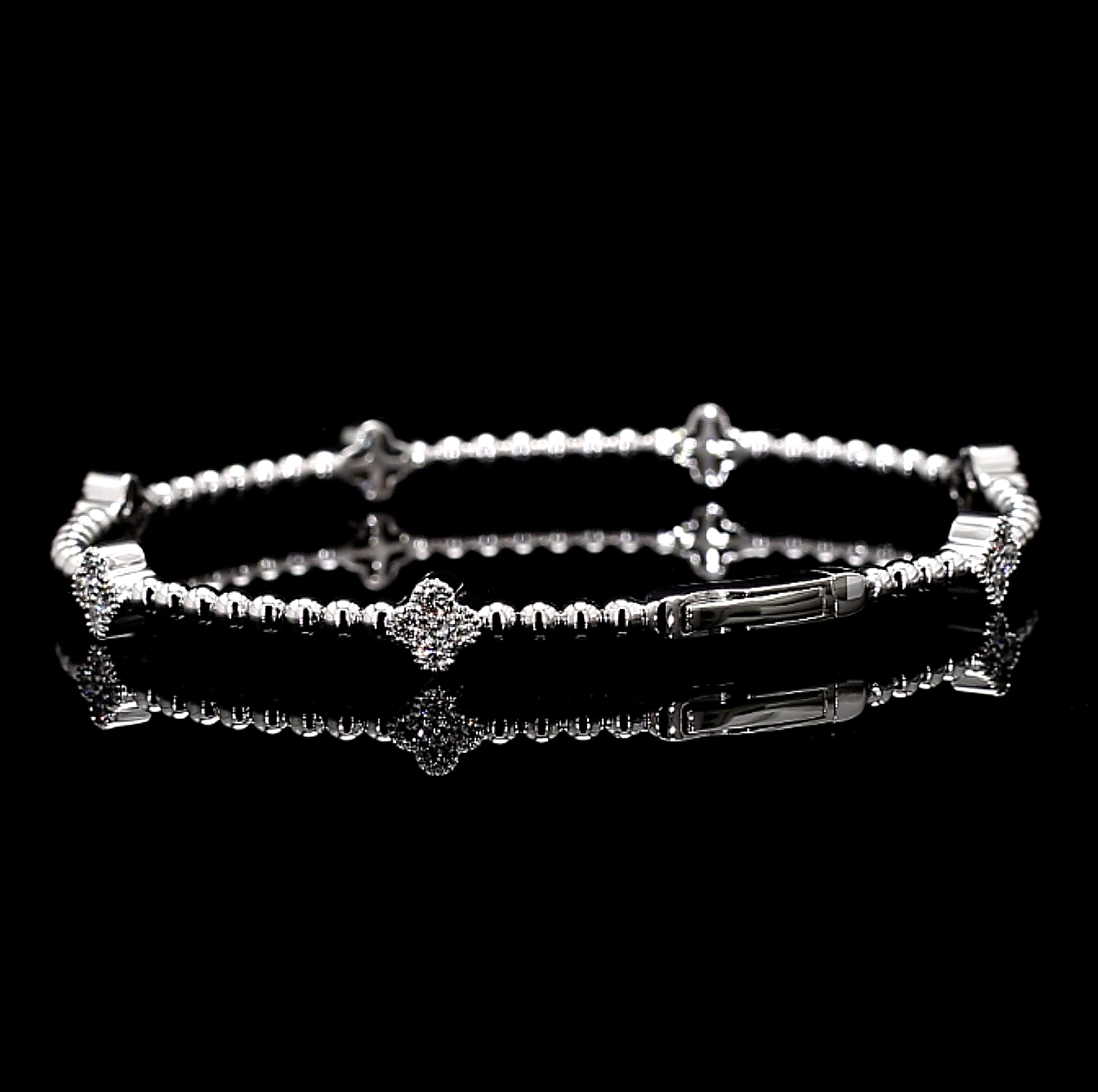White Gold bracelet with clover charm star and bar designs on a black background