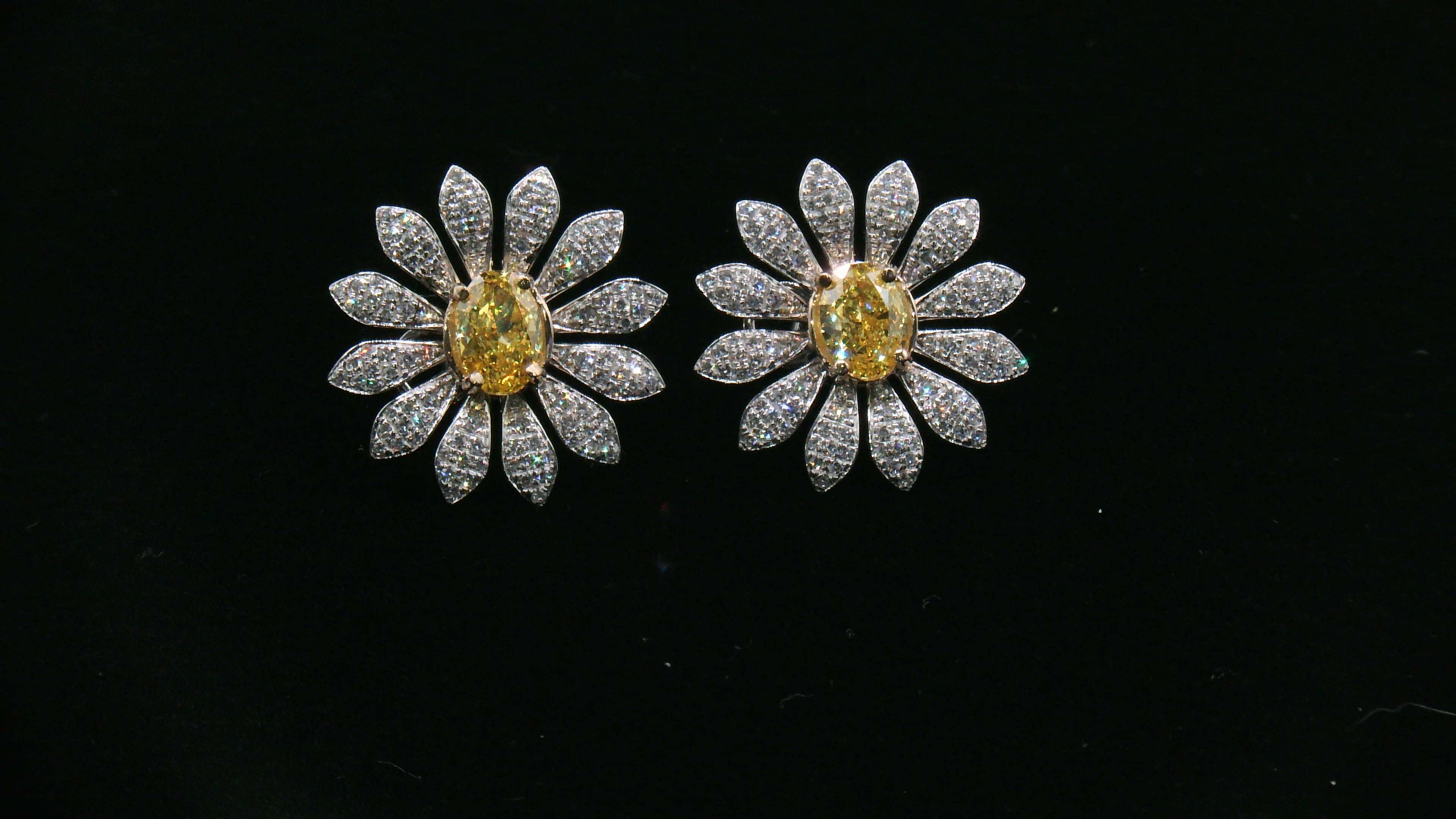 Pair of daisy-shaped diamond earrings with yellow diamond center stone 