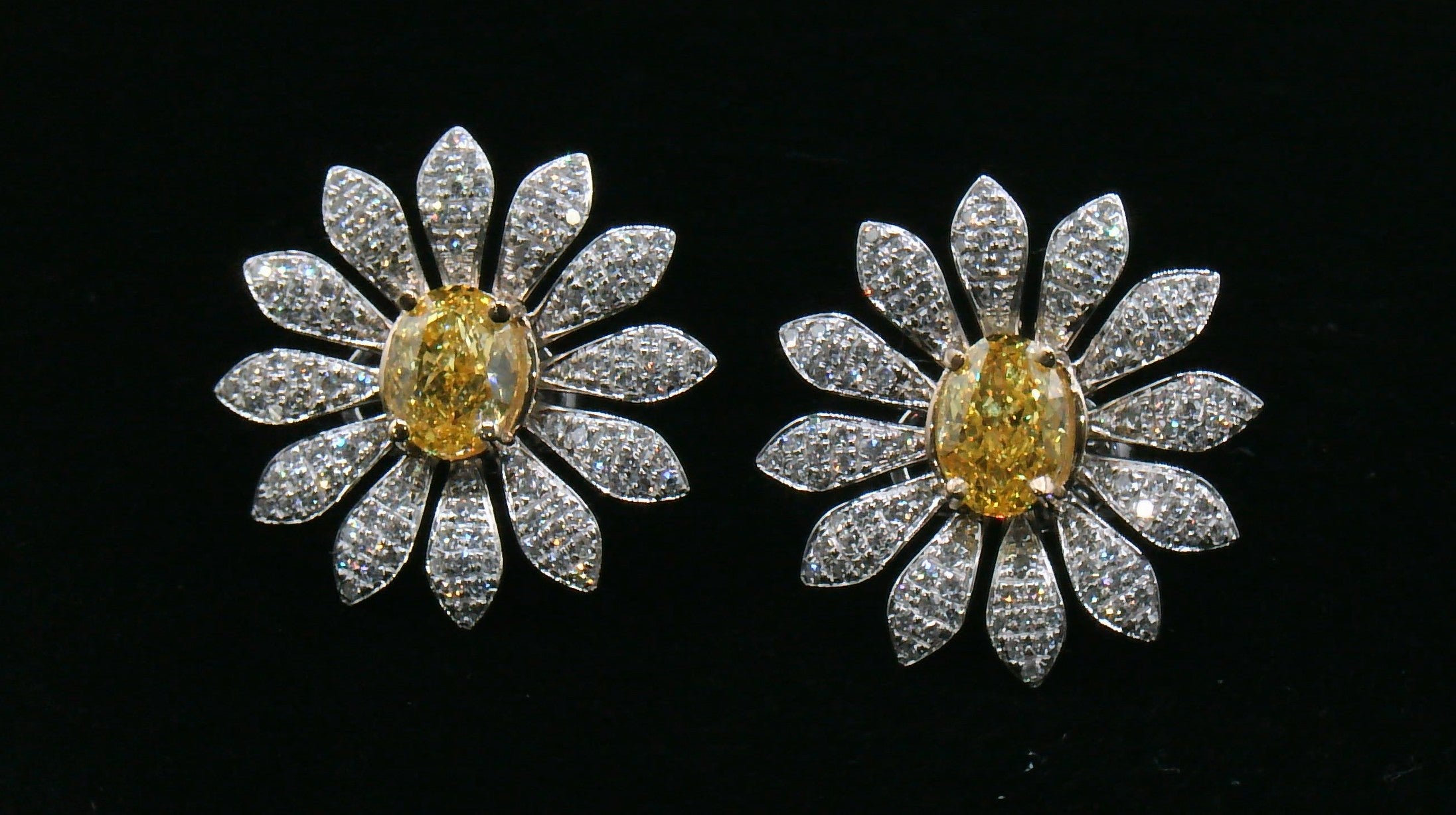 Pair of daisy-shaped diamond earrings with a yellow diamond center stone 