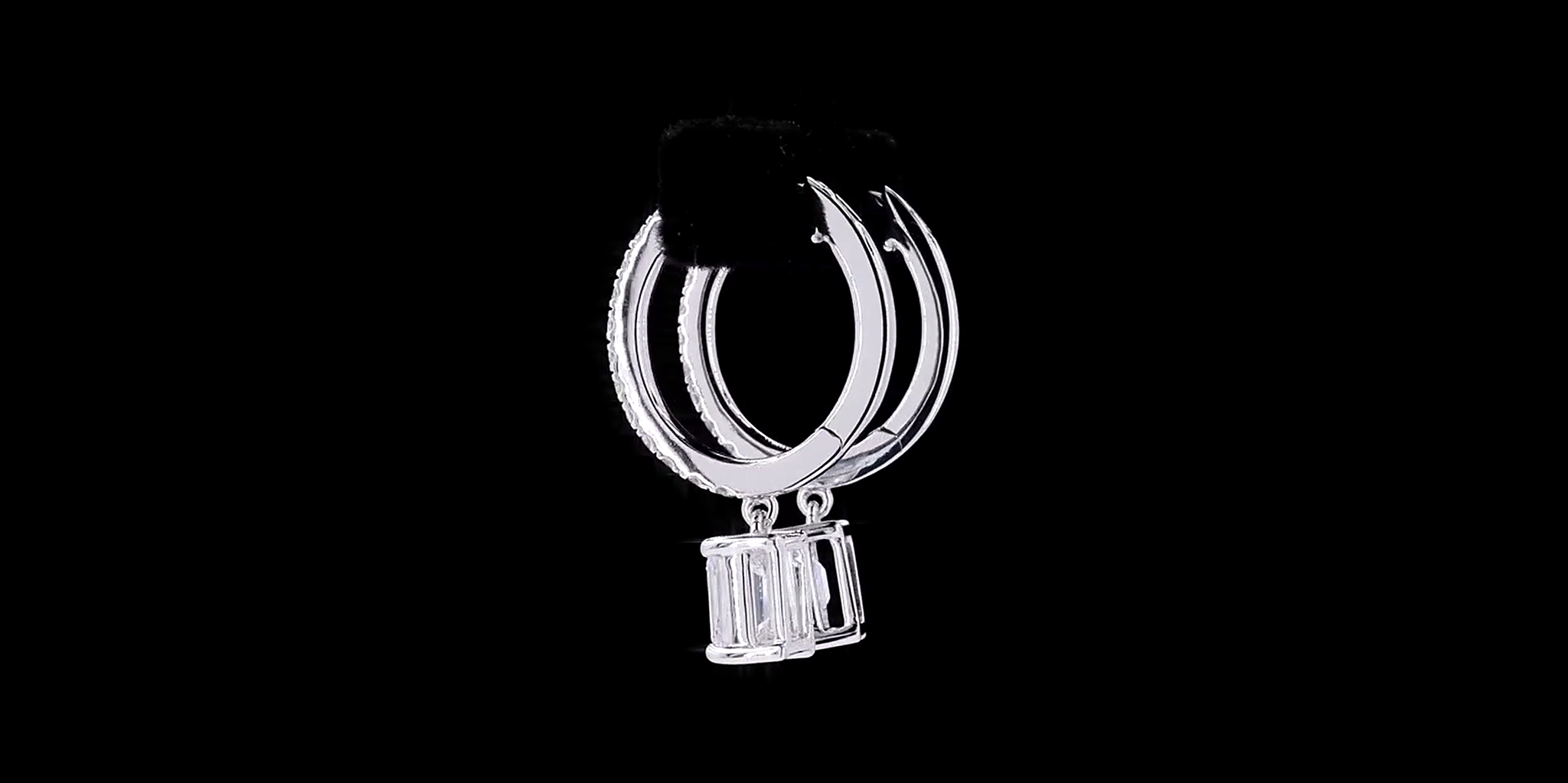 Pair of silver hoop earrings with Emerald cut diamond on a black background