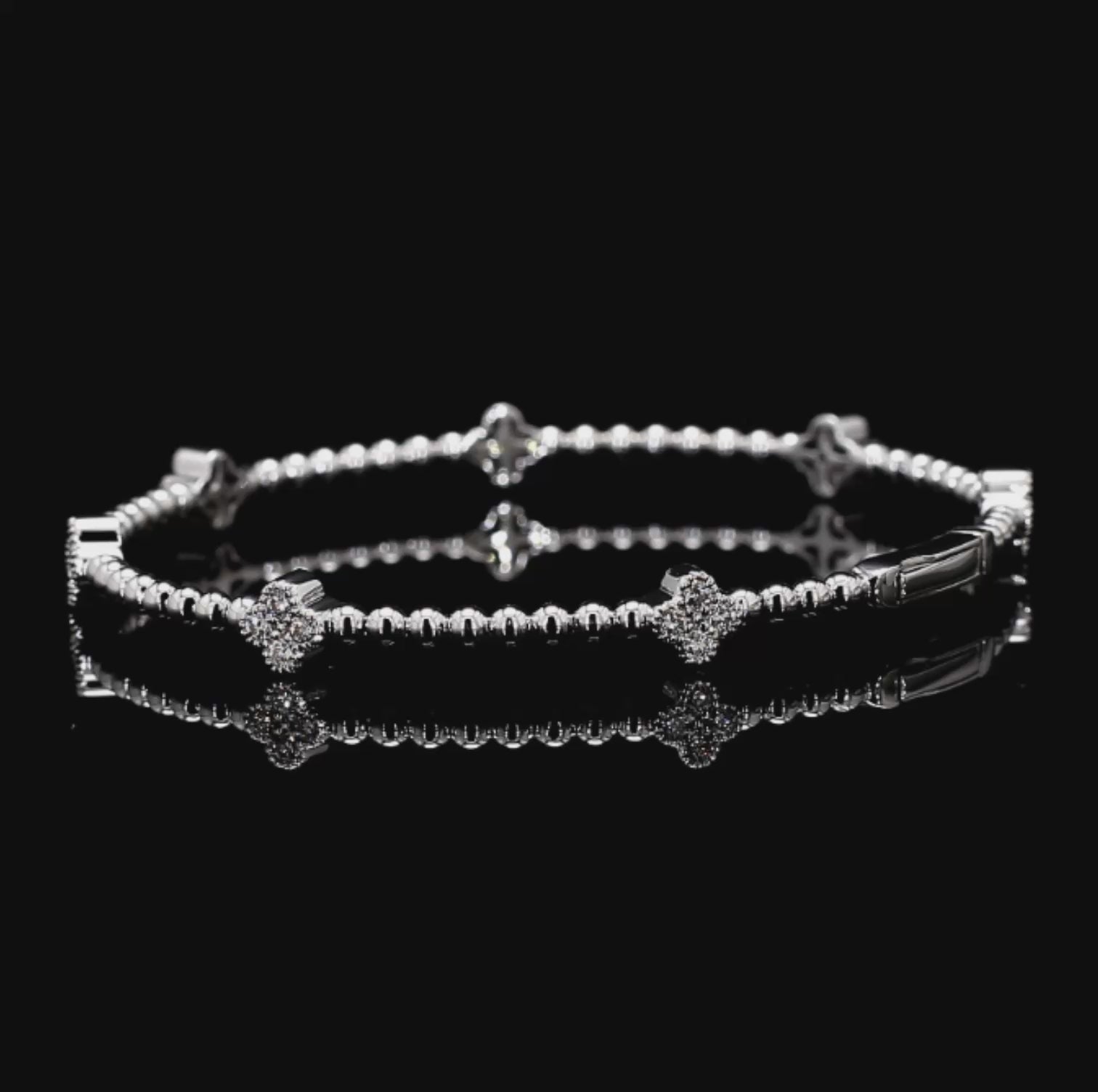 White Gold bracelet with clover charm star and bar designs on a black background